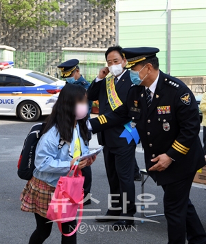 김영일 서장이 학생을 대상으로 디지털 성범죄 및 학교폭력 예방을 위한 홍보물품을 배포하고 있는 모습