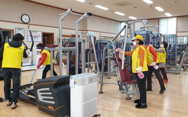 중부동 주민자치위원들이 자치센터 내 청소 및 방역을 실시하는 모습과 마친 후 함께 기념촬영을 하는 모습.