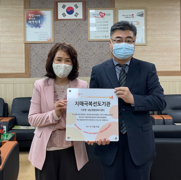 성현진 건강증진과장과 백상희 내남면장에게 현판을 수여한 후 함께 기념촬영을 하는 모습