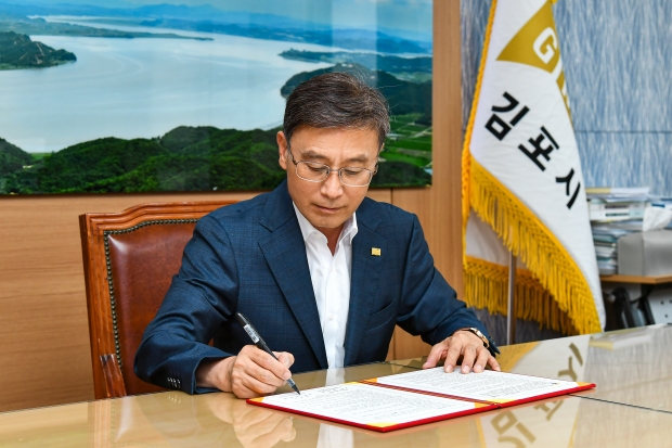 정하영 김포시장이 한강과 염하강 사업 협약서에 서명하고 있다.