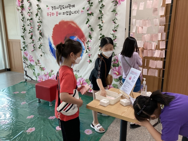 '무궁화 꽃이 피었습니다!' 포토존에서 어린이들이 100일 후 나의 모습을 종이에 적어 의지를 다지는 체험을 하고 있다