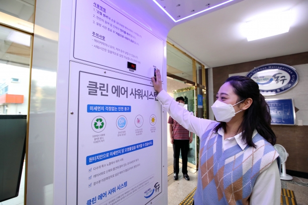동구청 공무원들이 본청 출입구에 설치된 에어샤워기를 시범 중인 현장