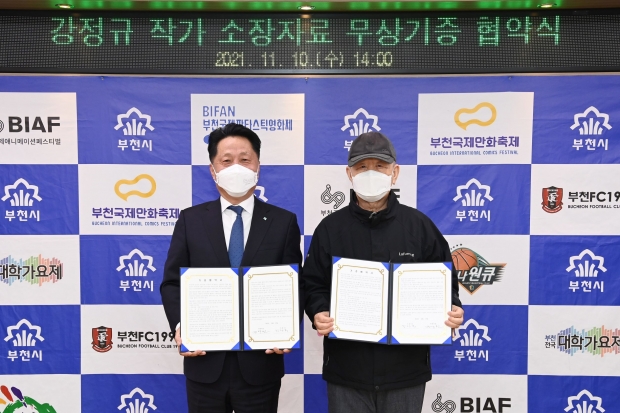 (왼쪽)장덕천 부천시장과 (오른쪽)강정규 동화작가가 협약서를 들고 기념촬영을 하고 있다