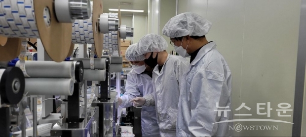 충남 천안에 위치한 자가진단키트 생산업체 ‘젠바디’에서 삼성전자 스마트공장 전문가와 젠바디 직원(가운데)이 자가진단키트 조립 라인을 점검하고 있다./사진 : 삼성전자