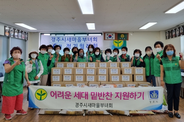 경주시 새마을부녀회원들이 7일 새마을회관에서 먹거리세트 지원행사를 진행하며 기념촬영하고 있다.