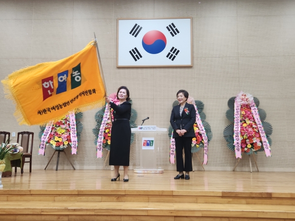 제13대 이근희 연합회장이 취임식에서 한국여성농업인강화연합회기를 전달받고 있다.