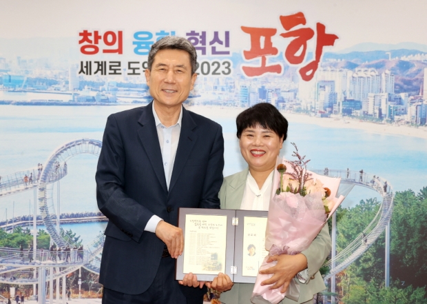 박주희 포항문화재단 사무국장(우측)이 31일 명예퇴직하며 이강덕 포항시장(좌측)에게 공로패를 수여받고 있다.