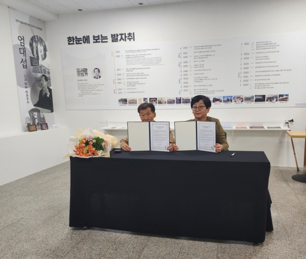 지난 8일 시립도서관 1층 로비에서 김윤근 선생(좌)과 최자숙 시립도서관장(우)이 함께 도서관 옛 자료 기증식을 가진 후 기념촬영을 하고 있다.
