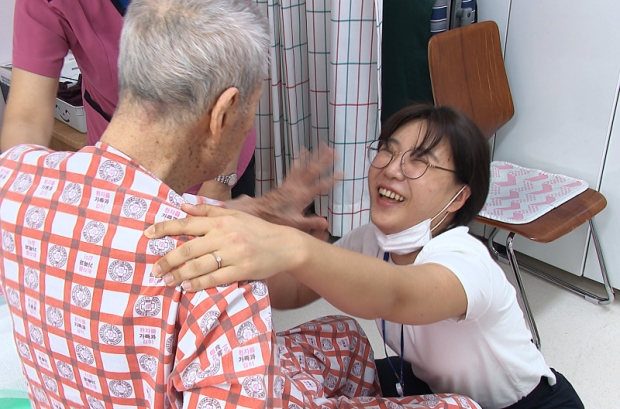 산책을 마치고 돌아온 김행선(90세, 알츠하이머 2016년 진단)할아버지가 송보름달 인천광역치매센터 간호사(휴머니튜드 전문교육자)와 하이파이브를 하고 있다.