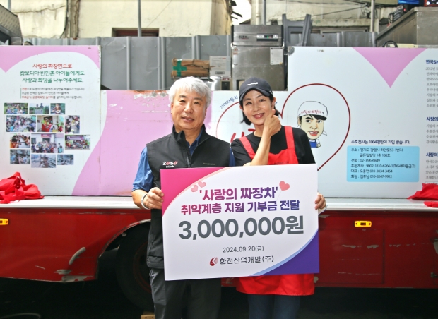 ▲함흥규 한전산업개발 사장(좌측)이 김예분 더브릿지 단장(우측)에 취약계층 지원 기부금 300만원을 전달하며 기념촬영에 응하고 있다.