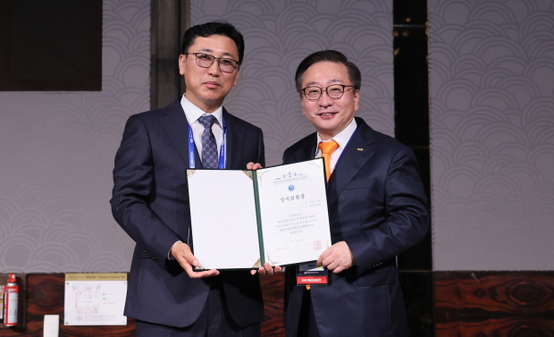 [사진자료] 진성곤 대웅바이오 대표(왼쪽)가 ‘대한신경외과학회 추계학술대회’에서 명예회원증을 받고 권정택 대한신경외과학회 이사장과 기념촬영을 하고 있다.