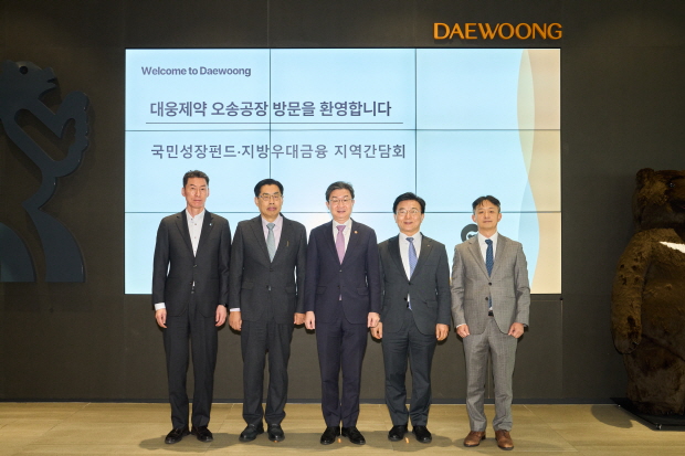 2월 12일 (왼쪽부터)장민영 IBK기업은행장, 윤재춘 대웅 대표, 이억원 금융위원장, 손영채 금융위원회 국민성장펀드추진단장, 박성수 대웅제약 대표 등 주요 관계자들이 대웅제약 오송 스마트 공장 방문을 기념해 기념촬영을 하고 있다.